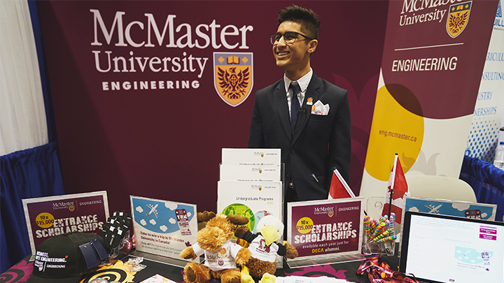 A student stands at a McMaster Engineering booth.