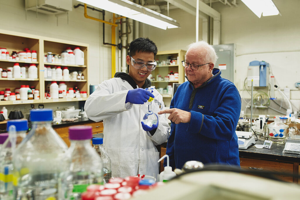Robert Pelton and a student inspect a flask in their lab