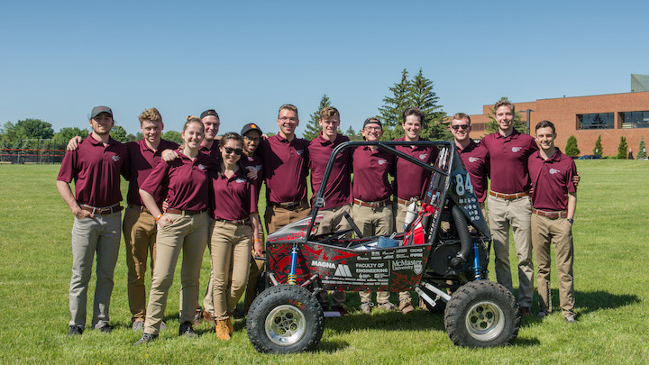 The Baja team posing in front of their baja racing car