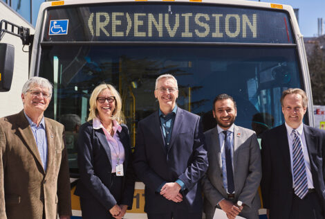 group of people posing in front of a Hamilton City bus.