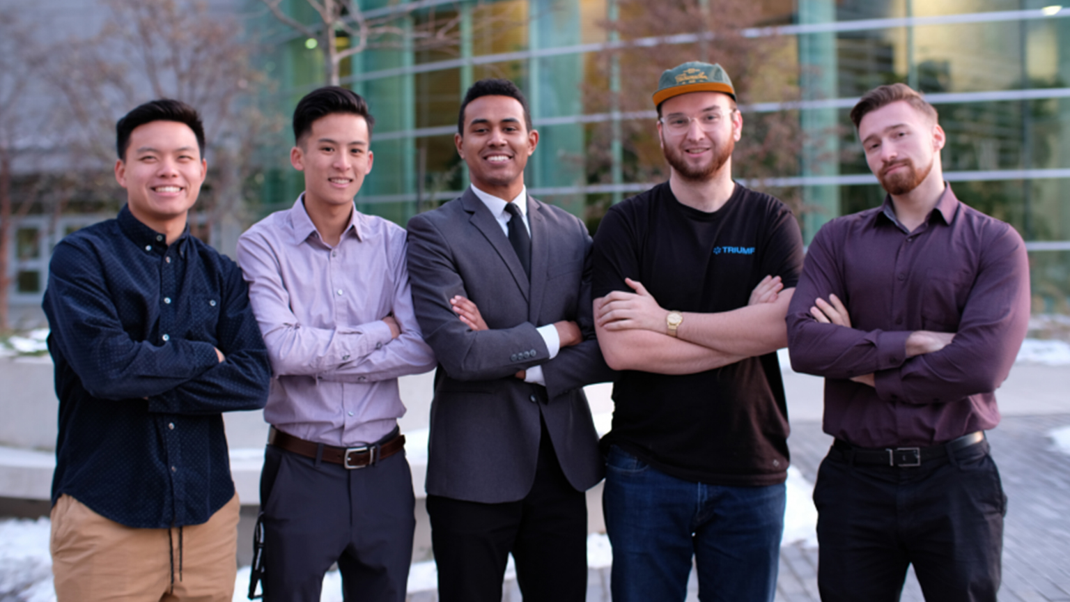 five guys standing next to one another for a group picture with their arms crossed.