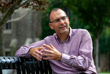 André Phillion sits on a bench motioning with his hands