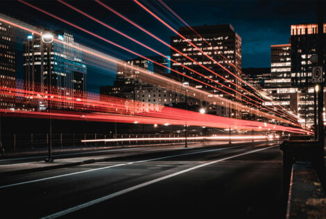 A city street at night with a light effect showing lines of red light going down the street