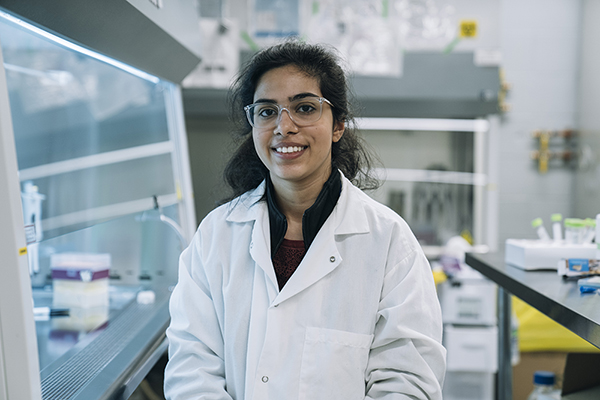 A smiling woman poses in a McMaster lab
