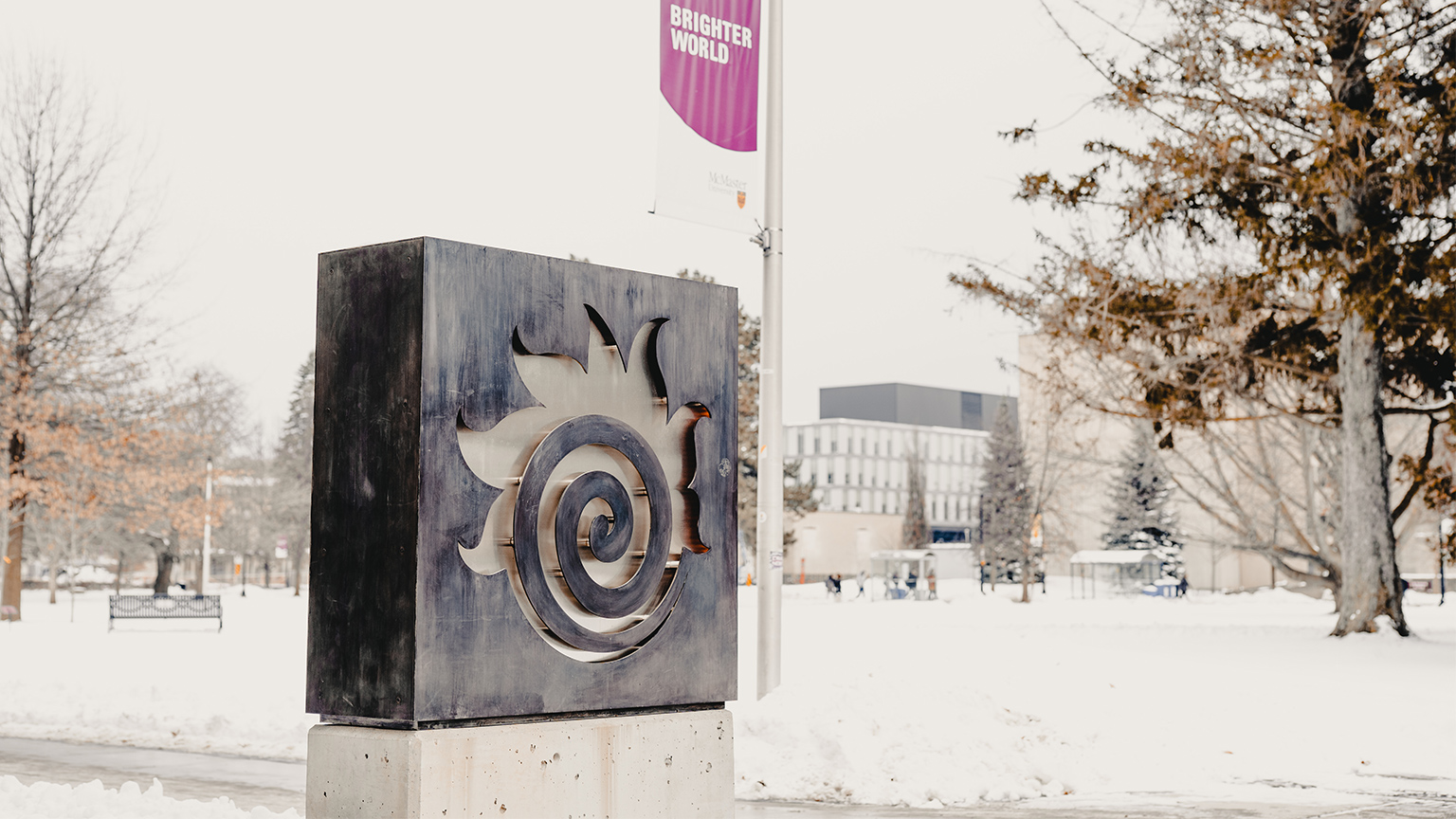 A fireball sign outside Hatch with a snow covered campus in the background