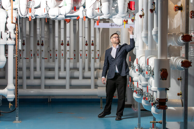 Jim cotton stands in a room with pipes.
