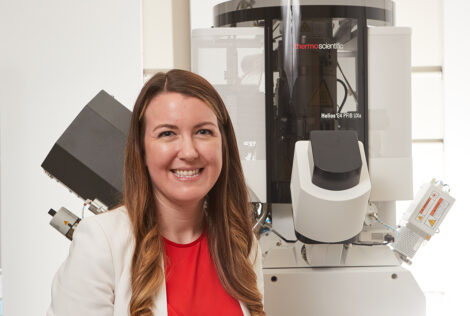 Kathryn Grandfield poses in front of a thermoscientific machine