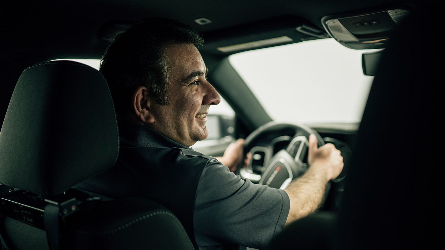 Ali Emadi sits behind the steering wheel of a vehicle.