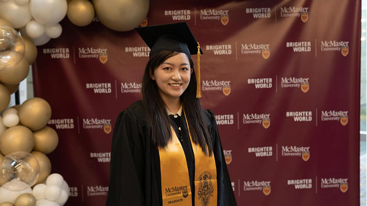Jessica Lei poses for a picture in a cap and gown.