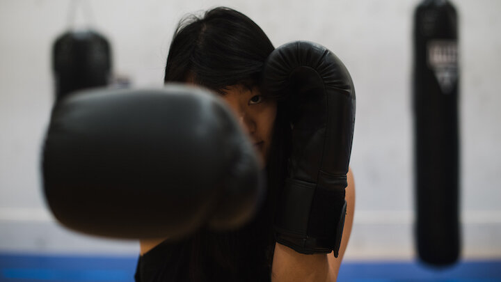 woman wearing boxing gloves throwing a punch.