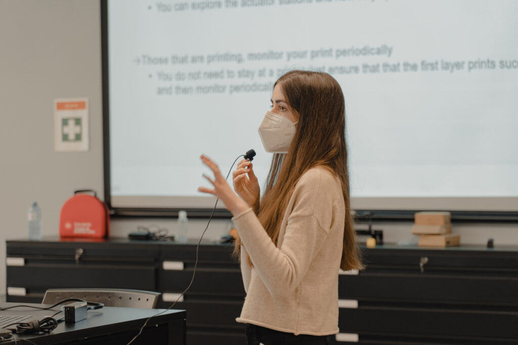 A person presenting to the class holding a small microphone