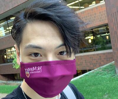 Calvin Zhu outside of Thode wearing a McMaster face mask