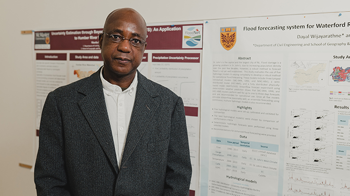 Paulin Coulibaly stands in front of a research poster.