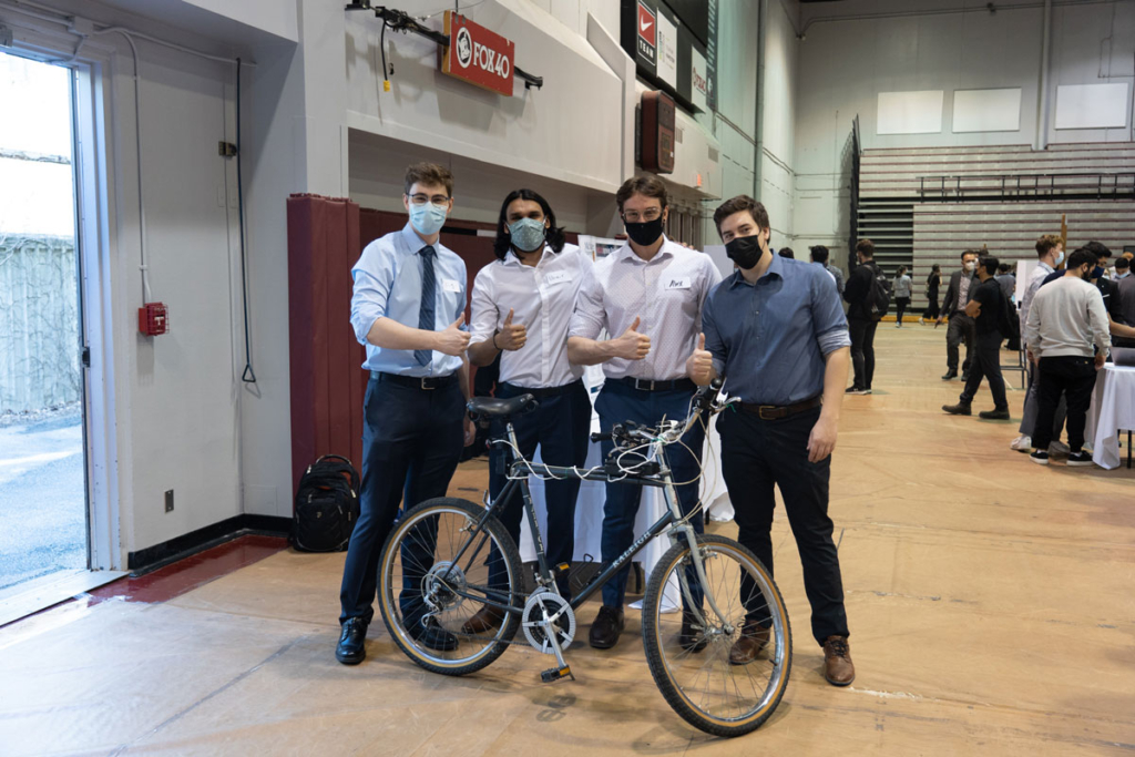 The Cycle Safe capstone group pose with their bike prototype while all giving the thumbs up.