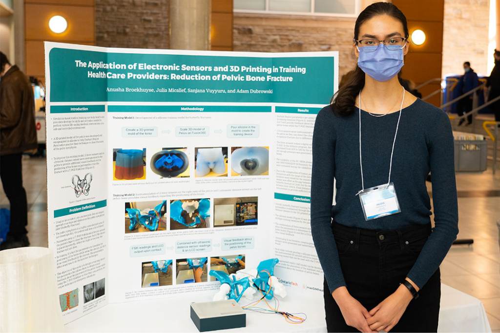 Anusha Broekhuyse poses in front of their poster.