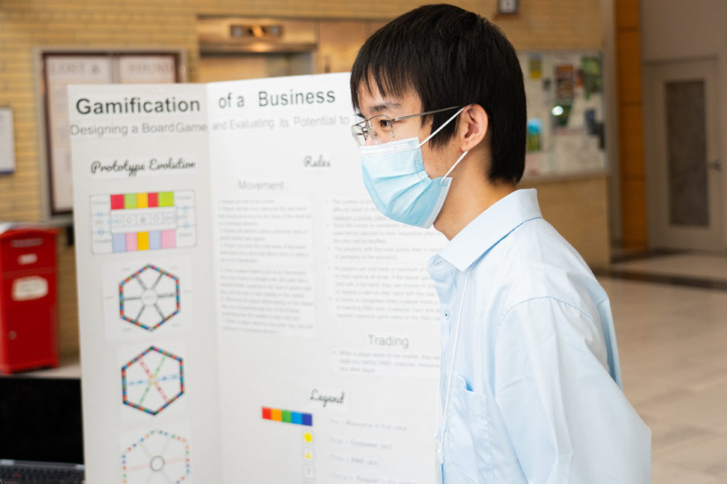 Eugune Wu stands by his research poster.