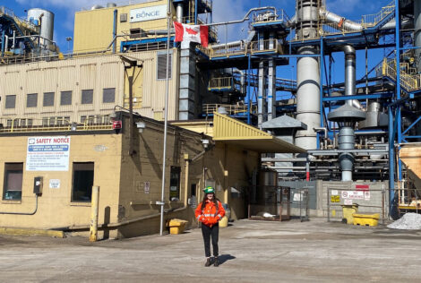 Shayna Earle stands in front of Bunge wearing a safety vest and hard hat