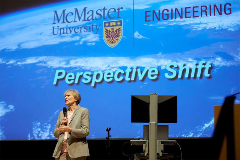 Roberta Bondar speaks to an audience in front of a slide that says "Perspective Shift"