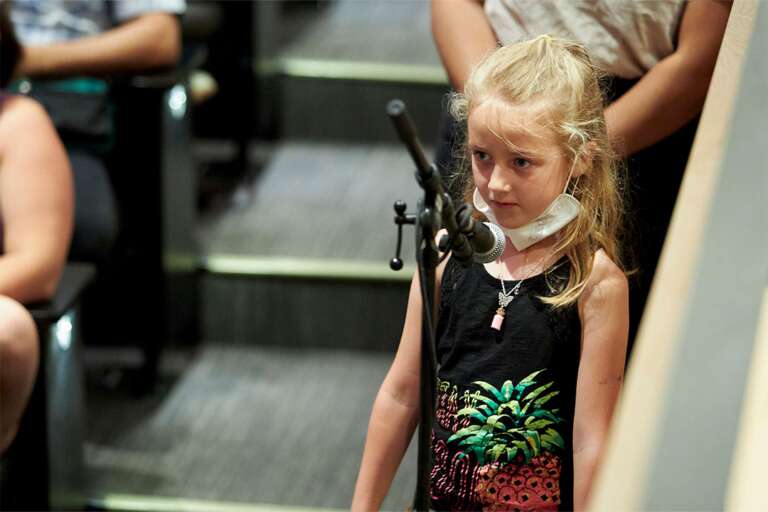 A young girl stands at a mic to ask Roberta Bondar for advice for little kids.