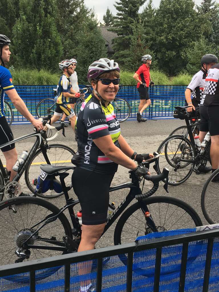 Heather Sheardown in cycling gear standing beside her bike