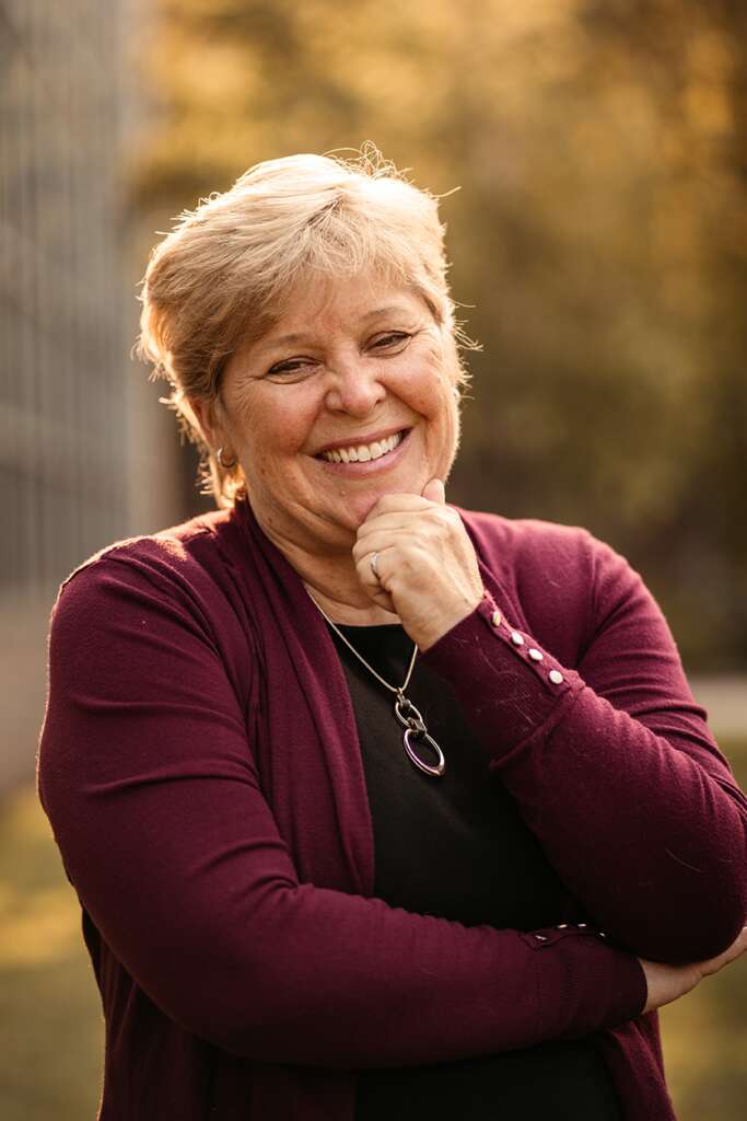 Heather Sheardown poses with her hand on her chin smiling