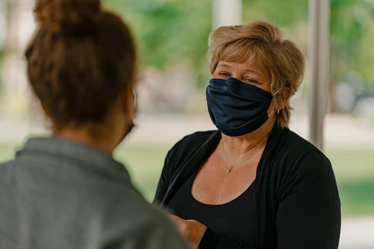 Heather speaks to a student while wearing a McMaster Engineering face mask