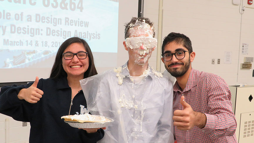 Colin McDonald has been pied in the face, two people stand on either side of them giving the thumbs up