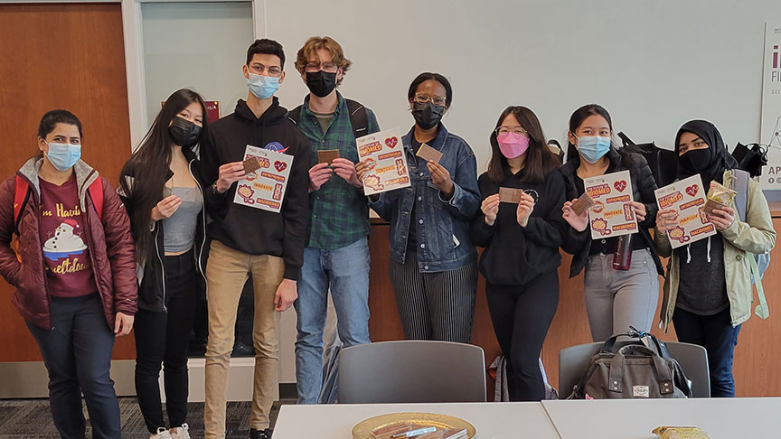 group of students holding up iBioMed sticker sheets