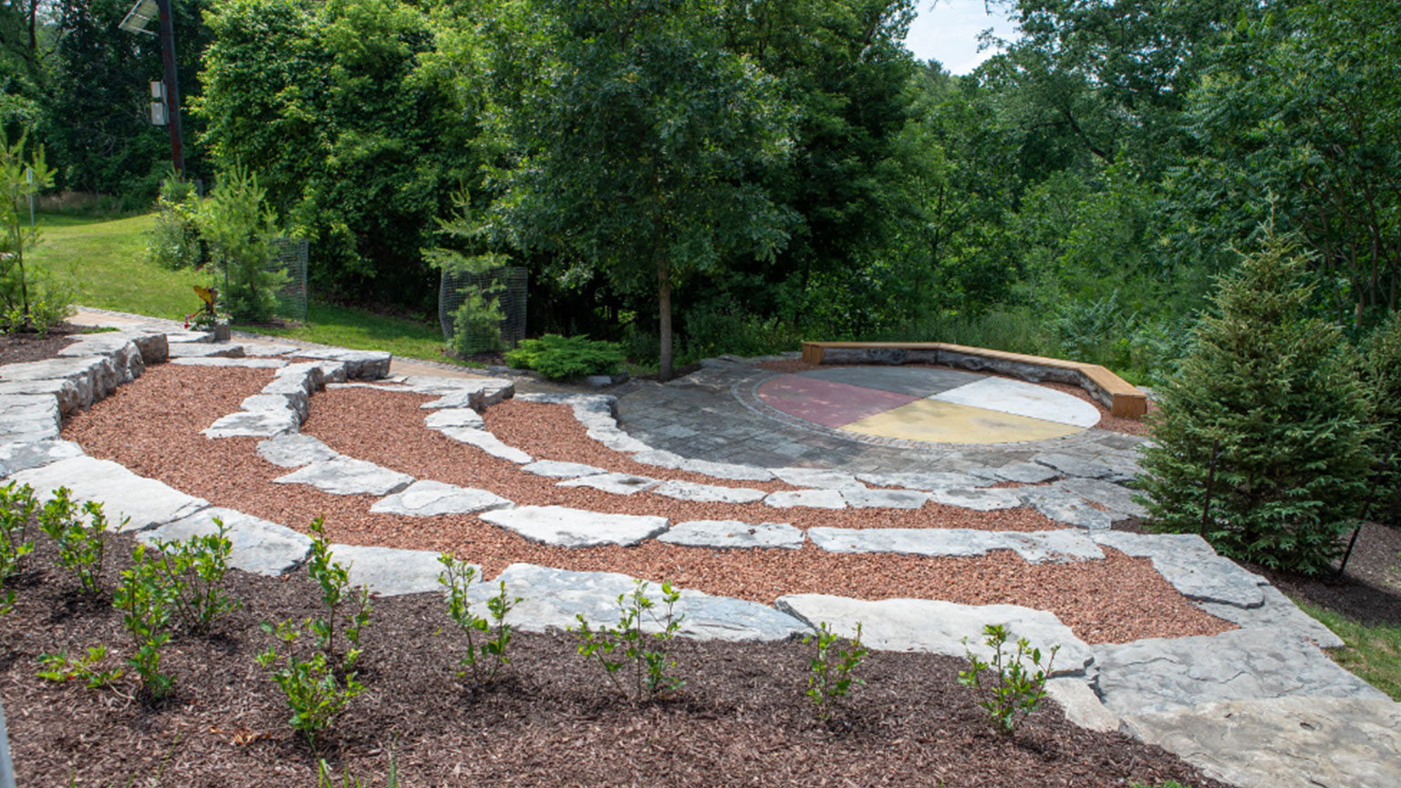 The Indigenous Circle features tiered stone arranged around a stage in the form of a medicine wheel, a symbol that represents the interconnectivity of all beings. Plantings in the space were sourced from Six Nations of the Grand River