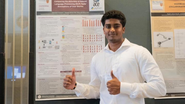 Sathurshan giving the thumbs up in front of their poster