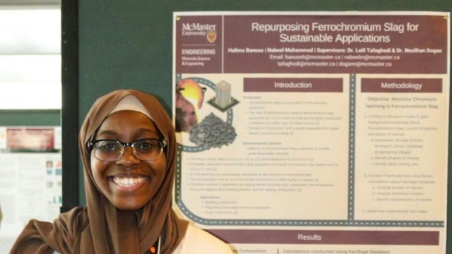 Halima smiles beside her poster