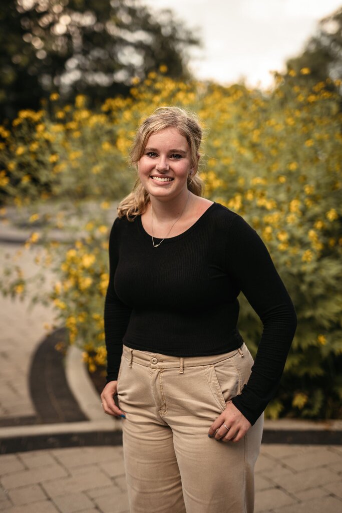 Chelsey Ellis stands in front of a  tree.