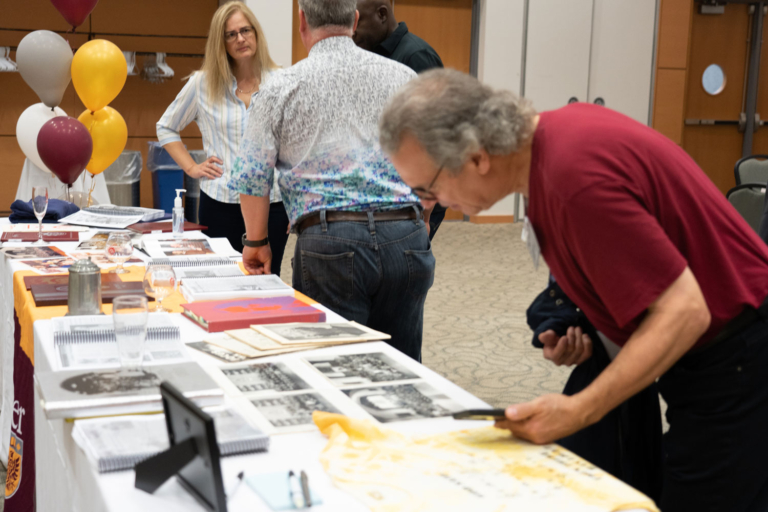 a person leans over to inspect photos on a table