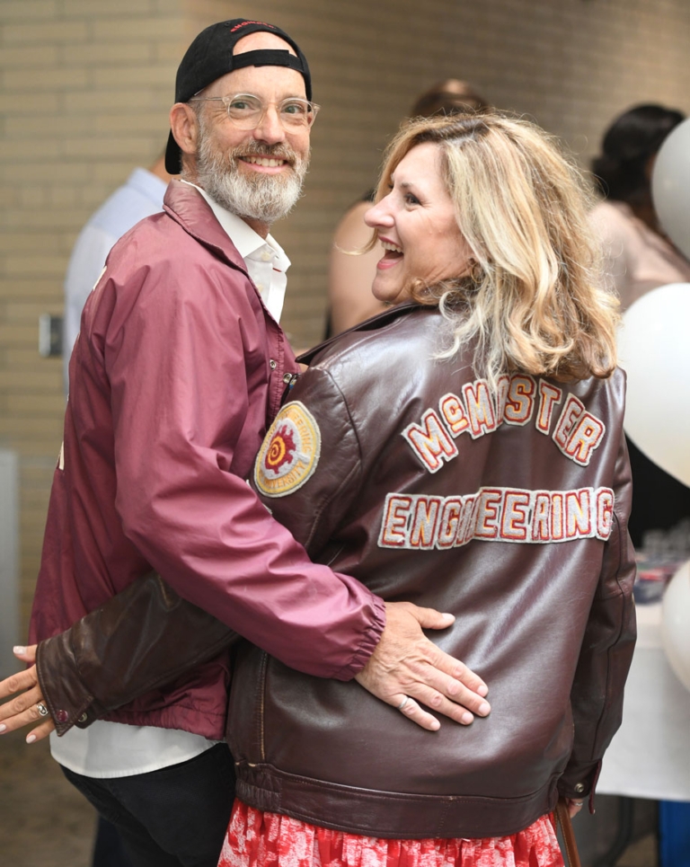 Two grads wearing vintage leather engineering jacket and a maroon athletic jacket
