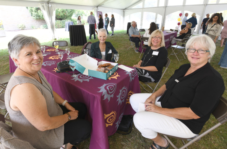 four grads sit around a table covered in fireballs