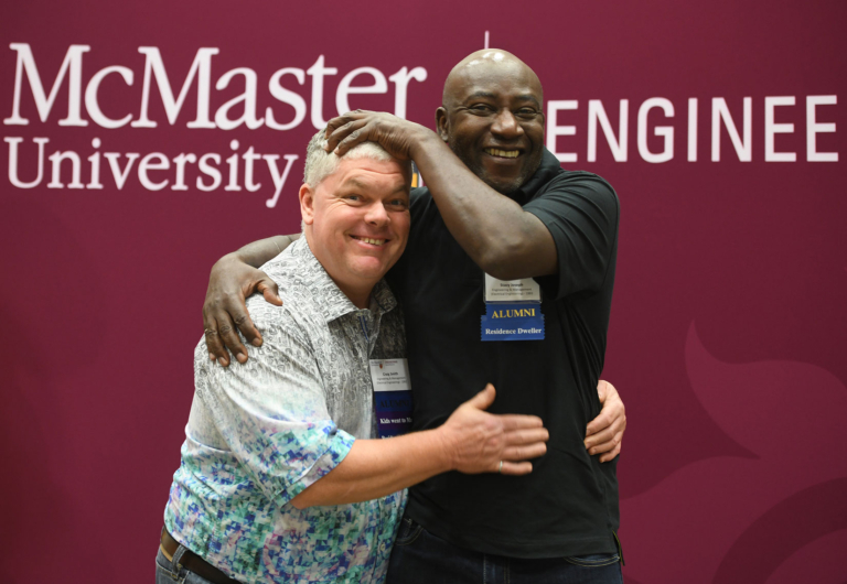 Two grads pose hugging each other