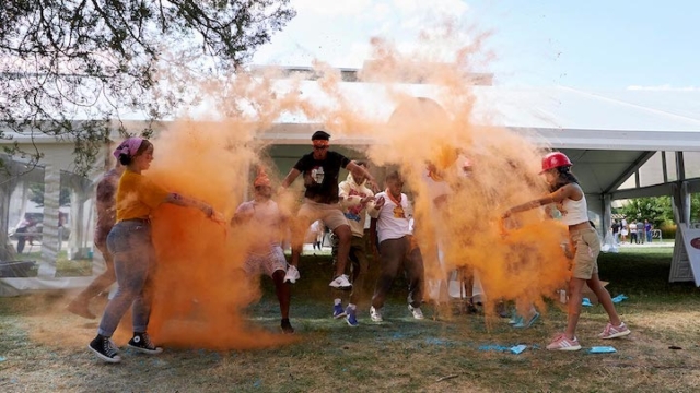 group of people jumping in orange powder.