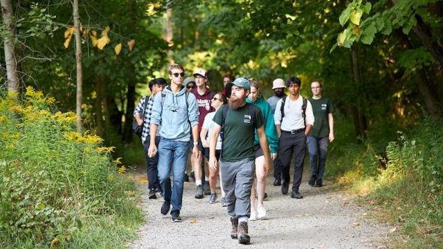 group of people walking on a nature trail.