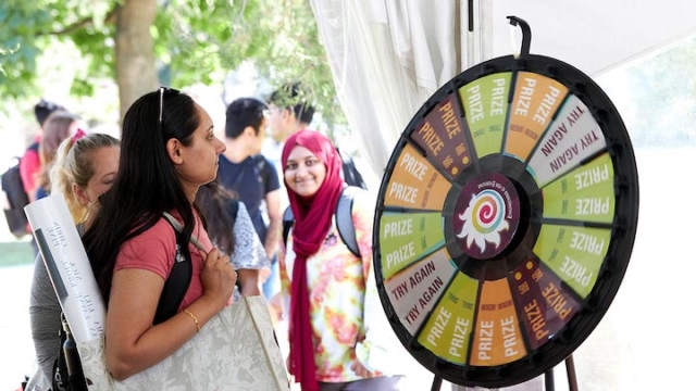 student in front of a prize wheel.