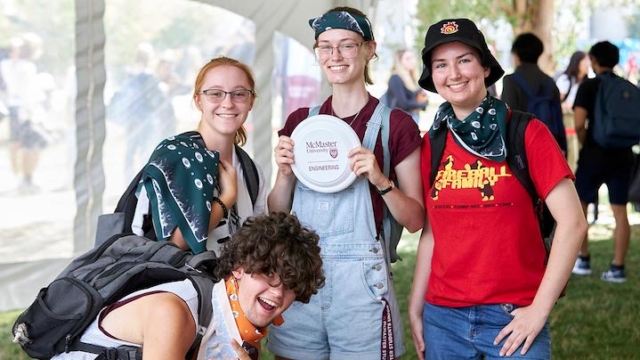 group of four students smiling and posing.