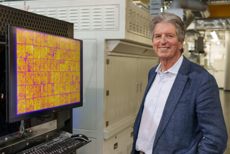 Martin Green poses in a lab next to a TV screen