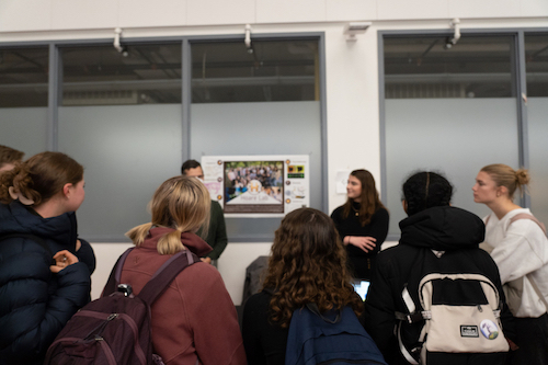 group of people looking at a presentation board. 