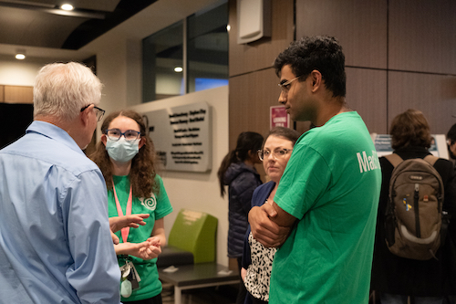 a group of student presenting to a person. 