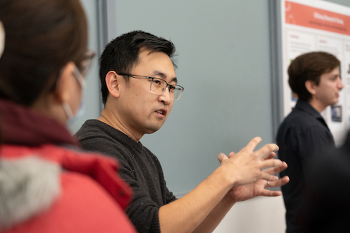 a close-up of someone explaining their research to other people. 