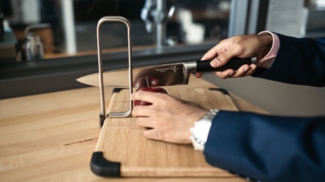 an apple being but on a cutting board.