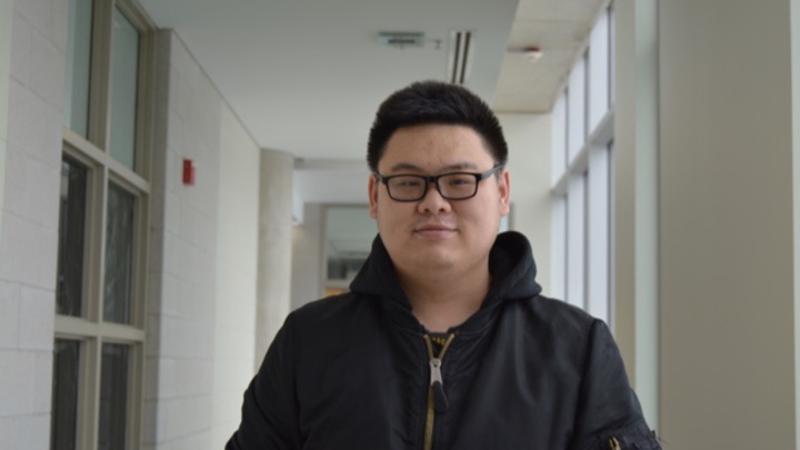 headshot of person in a hallway.