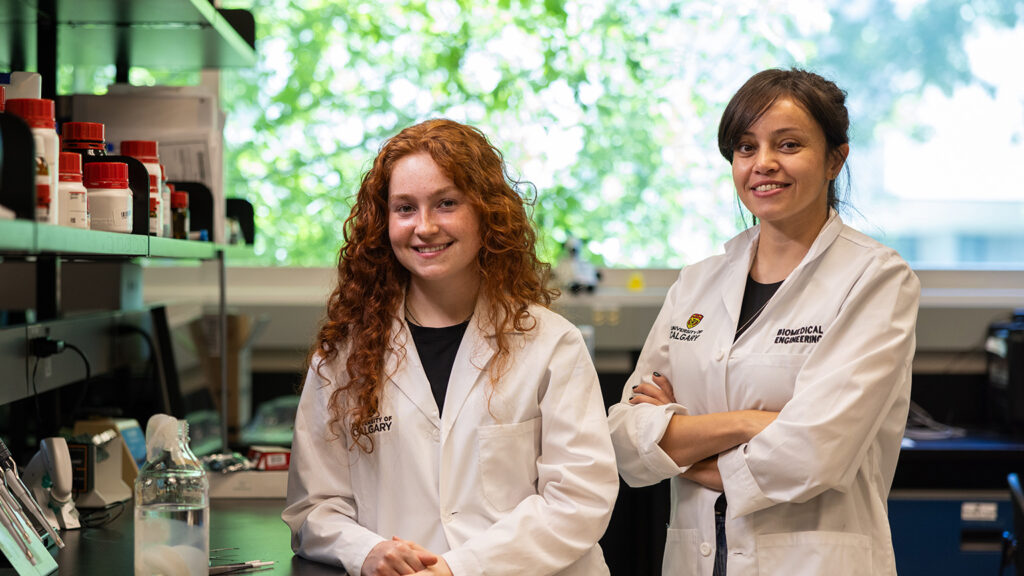 Grad Maryam Badv and student Shannon Gomes-Hunt pose in a University of Calgary lab