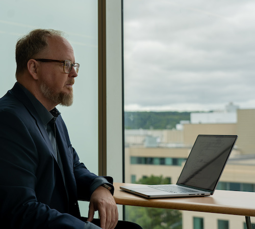 Tom Doyle sitting in front of a laptop.