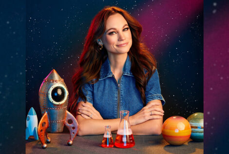 The Space Gal sits with space themed items on a table in front of her
