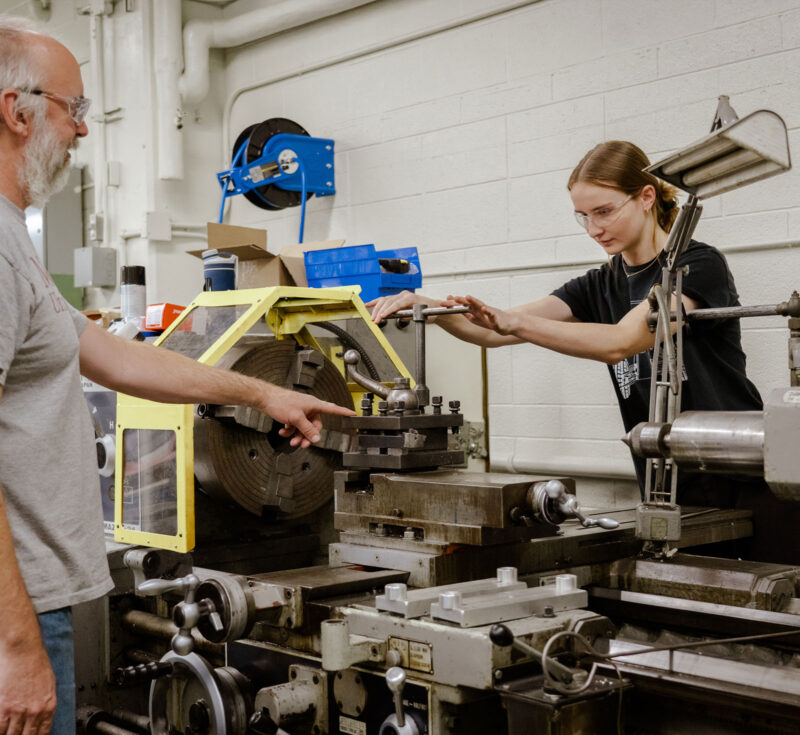 Student working on machine with instructor, Jim's guidance